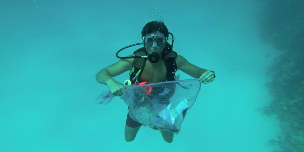 Volunteer diving and collecting plastic waste in the sea