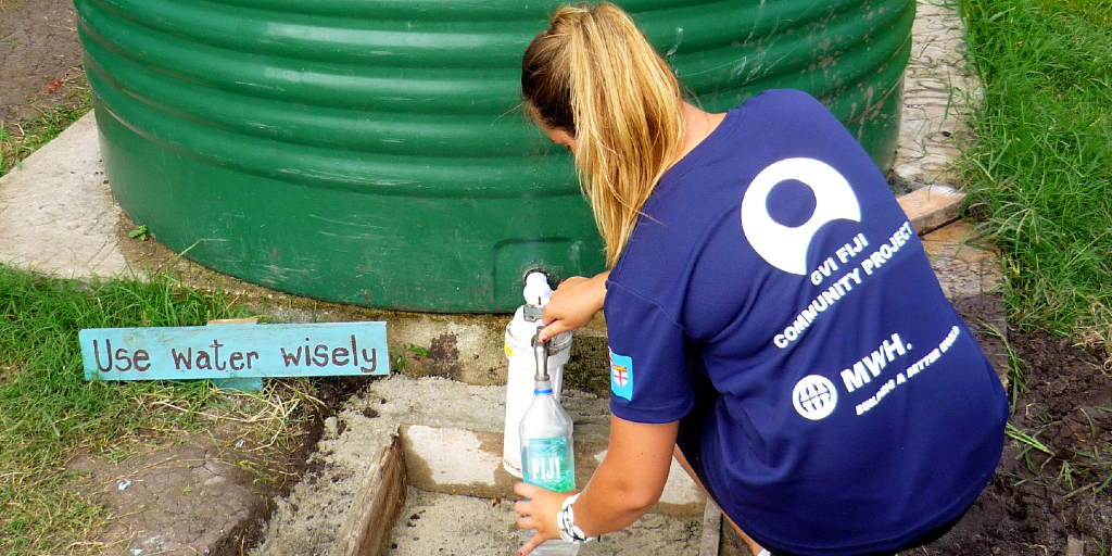 A GVI volunteer fills her water bottle with water. 