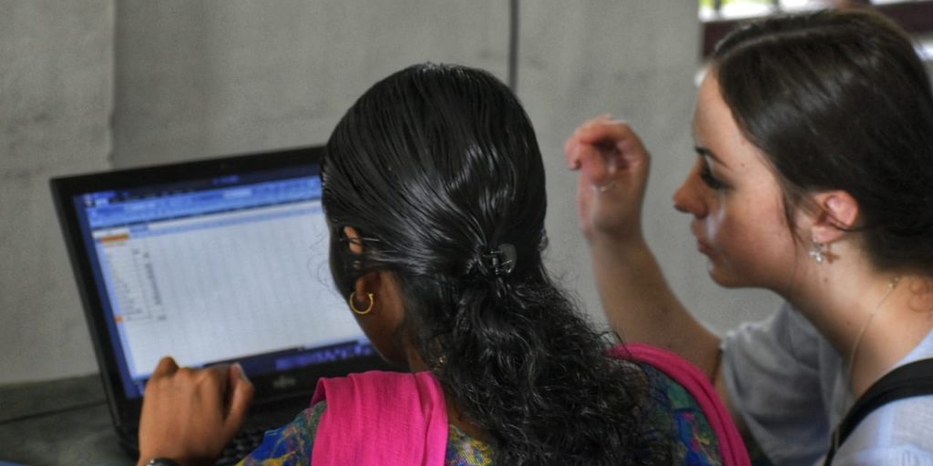 participants teaching local woman computer skills